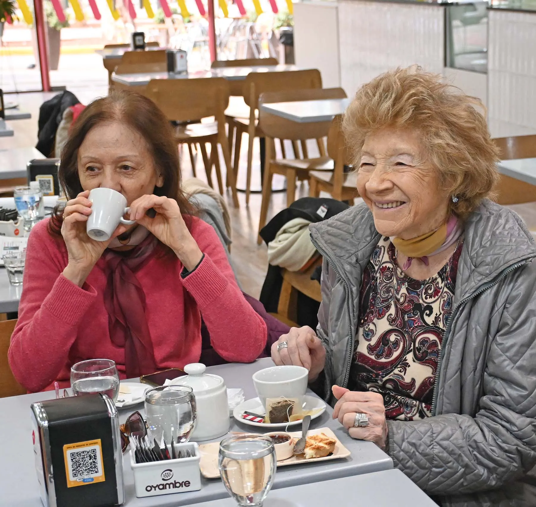 Blanca, paciente de Ámbar de 92 años, toma un café con una amiga. Foto de la nota del Diario Río Negro.