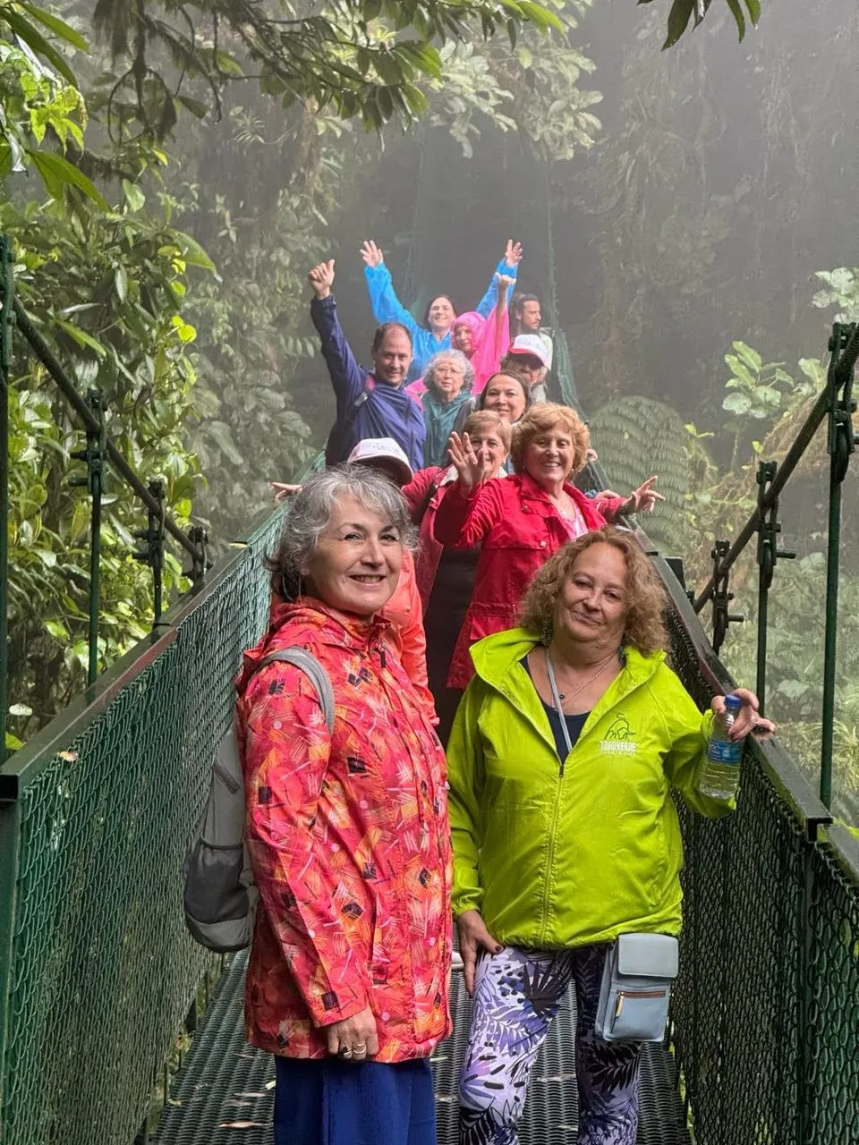 Grupo de participantes del Tour Pura Vida de Ámbar en un puente colgante en la selva de Costa Rica.